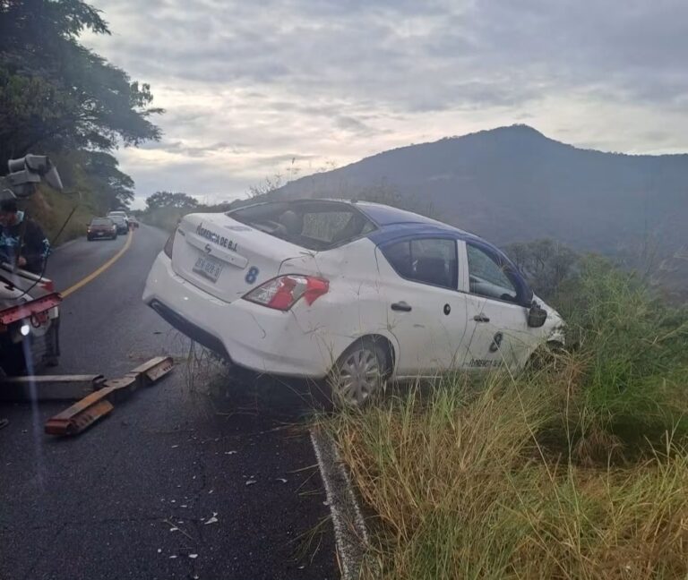 Termina taxi fuera del camino por pavimento mojado